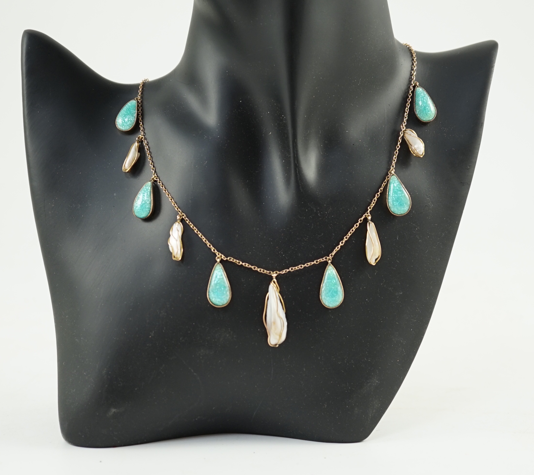 An early 20th century gold, enamel and baroque pearl set drop fringe necklace, in the manner of Liberty & Co